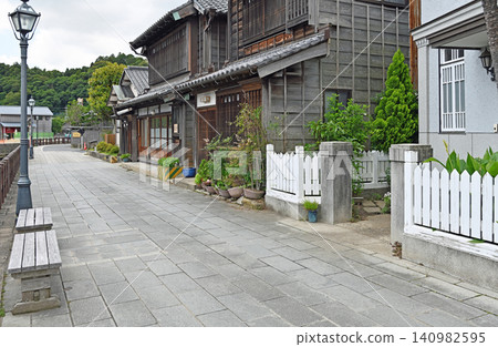 The cobblestone promenade of Sawara features a tranquil landscape lined with traditional wooden houses and retro white fences and streetlights. The cobblestone promenade of Sawara features a tranquil landscape lined with traditional wooden houses and retro white fences and streetlights. 140982595