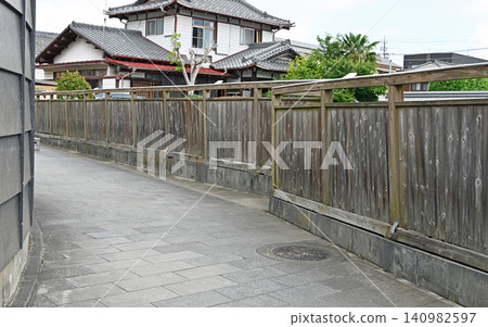 The gently curving cobblestone alleys of Sawara, with old houses visible beyond long wooden fences, create a charming and tranquil scene. The gently curving cobblestone alleys of Sawara, with old houses visible beyond long wooden fences, create a charming and tranquil scene. 140982597