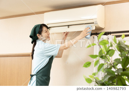 Female worker cleaning the house to clean the air conditioner Female worker cleaning the house to clean the air conditioner 140982793
