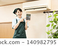 A female house cleaning worker holding a calculator 140982795