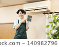 A female house cleaning worker holding a calculator 140982796