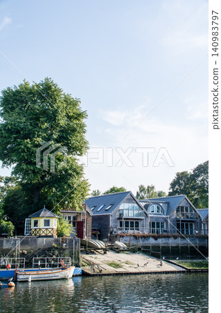 A small boat moored on the Thames River surrounded by greenery, near Eel Pie Island, outside London. A small boat moored on the Thames River surrounded by greenery, near Eel Pie Island, outside London. 140983797