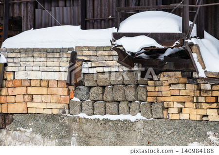 snow-covered pile of stones and bricks in hangar snow-covered pile of stones and bricks in hangar 140984188
