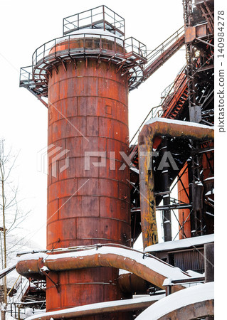 wide chimney in factory courtyard during snowfall wide chimney in factory courtyard during snowfall 140984278
