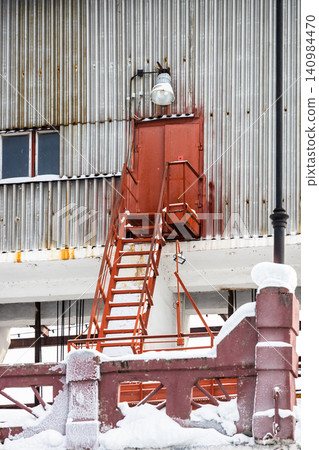 red stairs to tin wall of factory workshop red stairs to tin wall of factory workshop 140984470