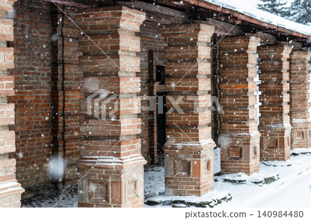 brick colonnade of old building during snowfall brick colonnade of old building during snowfall 140984480