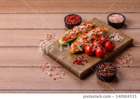 Baked zucchini half with minced meat, tomatoes, cheese, salt, and spices. Zucchini with minced meat Baked zucchini half with minced meat, tomatoes, cheese, salt, and spices. Zucchini with minced meat 140984555