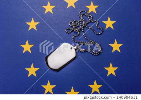 A dog tag on the European Union flag, serving as a conceptual backdrop A dog tag on the European Union flag, serving as a conceptual backdrop 140984611