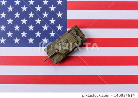 A tank on the US flag as a conceptual backdrop representing defense and preparation against attack A tank on the US flag as a conceptual backdrop representing defense and preparation against attack 140984614
