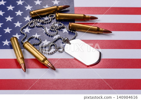 A dog tag on the US flag, serving as a conceptual backdrop representing defense A dog tag on the US flag, serving as a conceptual backdrop representing defense 140984616