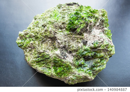 unworked green chrome diopside rock on black unworked green chrome diopside rock on black 140984887