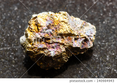 nworked chalcopyrite rock closeup on black granite nworked chalcopyrite rock closeup on black granite 140984943