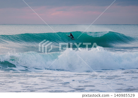 Surfer and crashing ocean wave. Surfing lifestyle and water sport concept. Surfer and crashing ocean wave. Surfing lifestyle and water sport concept. 140985529