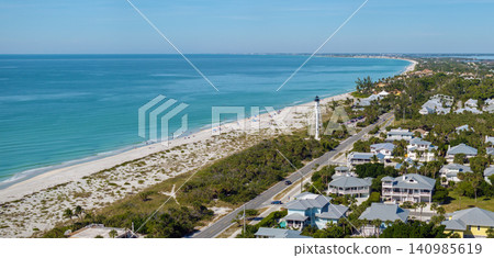 Expensive waterfront houses and white Boca Grande lighthouse on ocean shore. Small town on Gasparilla Island in southwest Florida. Premium housing development in the USA Expensive waterfront houses and white Boca Grande lighthouse on ocean shore. Small town on Gasparilla Island in southwest Florida. Premium housing development in the USA 140985619