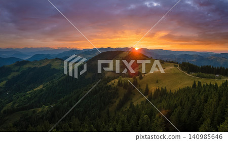 Amazing mountain landscape. Dark spruce woods illuminated with yellow setting sun. Bright colorful sunset in wild national park highlands Amazing mountain landscape. Dark spruce woods illuminated with yellow setting sun. Bright colorful sunset in wild national park highlands 140985646