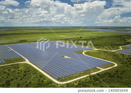Aerial view of big sustainable electric power plant with many rows of solar photovoltaic panels for producing clean electrical energy. Renewable electricity with zero emission concept Aerial view of big sustainable electric power plant with many rows of solar photovoltaic panels for producing clean electrical energy. Renewable electricity with zero emission concept 140985649