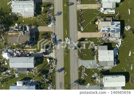 Hurricane strong wind destroyed suburban house roofs in Florida mobile home residential area. Consequences of natural disaster Hurricane strong wind destroyed suburban house roofs in Florida mobile home residential area. Consequences of natural disaster 140985656
