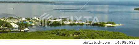 Aerial view of Florida wetlands with green vegetation between ocean water inlets and distant residential houses. Natural habitat of many tropical species Aerial view of Florida wetlands with green vegetation between ocean water inlets and distant residential houses. Natural habitat of many tropical species 140985682