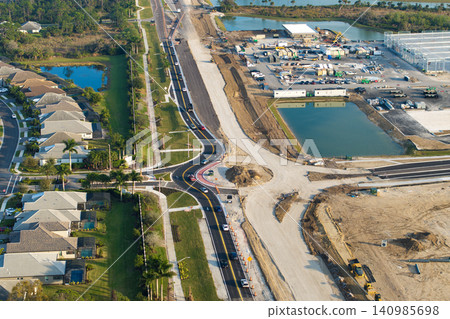 Driving traffic cars at roundabout intersection under construction. Building traffic circle on American road with moving cars 140985698