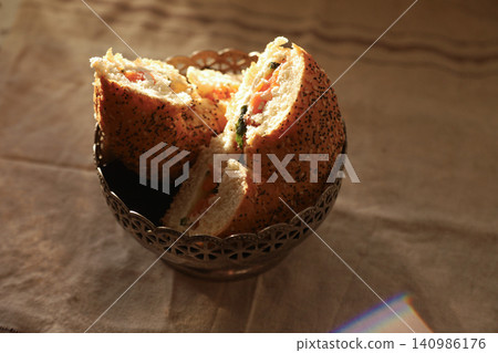 Sliced savory bread rolls with salmon and herbs in a glass bowl 140986176
