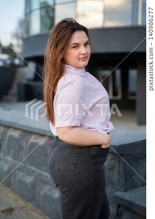 Confident professional woman standing outside modern office building in urban environment. Casual business portrait and professional lifestyle Confident professional woman standing outside modern office building in urban environment. Casual business portrait and professional lifestyle 140986277