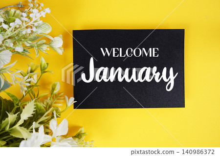 Welcome January text written on paper card with flowers decoration on yellow background Welcome January text written on paper card with flowers decoration on yellow background 140986372
