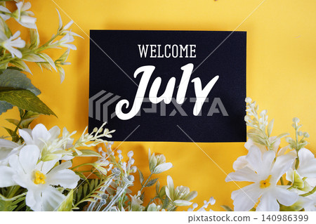 Welcome July text written on paper card with flowers decoration on blue background Welcome July text written on paper card with flowers decoration on blue background 140986399