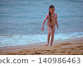Little girl playing with yellow shovel on tropical beach Hikkaduwa Sri Lanka 140986463