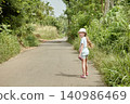 Monitor lizard running across countryside road as girl stands amazed 140986469