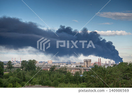 Major fire at oil refinery production facility with thick smoke rising from industrial area Major fire at oil refinery production facility with thick smoke rising from industrial area 140986569