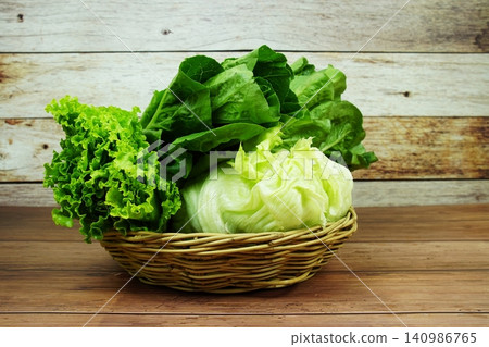 Fresh raw Iceberg, Romaine and Green Cos lettuces in bamboo basket on wooden background Fresh raw Iceberg, Romaine and Green Cos lettuces in bamboo basket on wooden background 140986765
