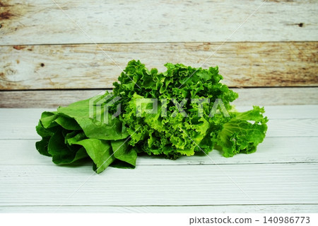 Fresh raw Iceberg, Romaine and Green Cos lettuces on wooden background Fresh raw Iceberg, Romaine and Green Cos lettuces on wooden background 140986773