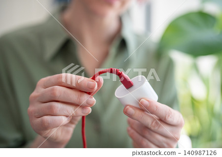Woman demonstrating smartphone charging adapter with damaged broken cable sticking out of usb port Woman demonstrating smartphone charging adapter with damaged broken cable sticking out of usb port 140987126