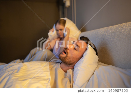 Exhausted female with sleep deprivation and insomnia suffering from partner snoring at night. Exhausted female with sleep deprivation and insomnia suffering from partner snoring at night. 140987303