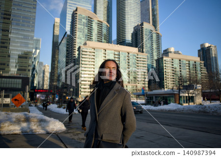 Woman Walking Along Waterfront Street With City Skyline Woman Walking Along Waterfront Street With City Skyline 140987394