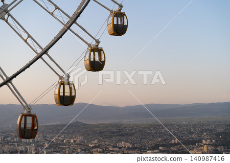 Ferris wheel in Mtatsminda amusement park in Tbilisi, Georgia. Giant wheel at sunset Ferris wheel in Mtatsminda amusement park in Tbilisi, Georgia. Giant wheel at sunset 140987416