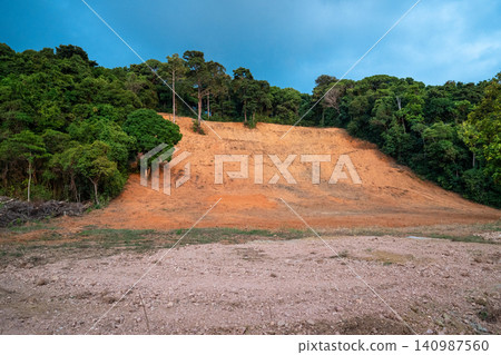Large deforested area surrounded by hill with green tropical rainforest in Asia, unique jungles in Thailand and Vietnam destroyed by nature erosion and human impact. 140987560