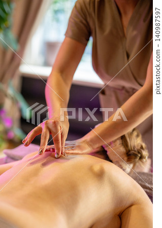 Beauty procedure and body care treatment, professional masseuse making therapeutic massage for woman 140987597