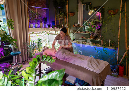 Body care and beauty rituals, professional masseuse providing relaxing massage for female client. Body care and beauty rituals, professional masseuse providing relaxing massage for female client. 140987612