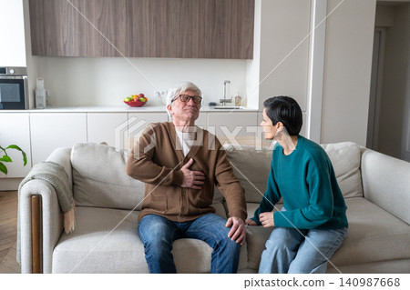 Worried senior wife with concerned scared expression looking at husband suffering from heart attack. Worried senior wife with concerned scared expression looking at husband suffering from heart attack. 140987668