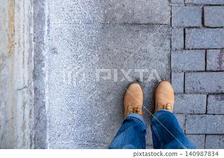 Anti-icing chemicals in winter. Top view of boots and asphalt strewn with technical salt or reagents Anti-icing chemicals in winter. Top view of boots and asphalt strewn with technical salt or reagents 140987834