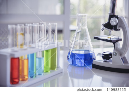 Science laboratory chemistry test science lab with microscope, glass tubes, chemical beaker white table scientific background. Colorful Liquid biology laboratory chemical fluid scientist experiment 140988335