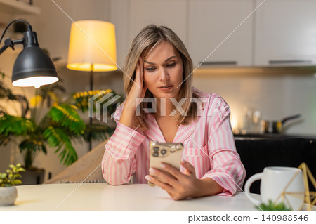 Adult woman scrolls news on smartphone bored tired stressed demotivated seeks calm break at night Adult woman scrolls news on smartphone bored tired stressed demotivated seeks calm break at night 140988546