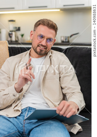 Young man drafts daily plan in notebook sets priorities makes schedule and maps tasks for week plans Young man drafts daily plan in notebook sets priorities makes schedule and maps tasks for week plans 140988631