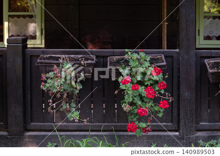 Rustic porch with red geranium flower boxes Rustic porch with red geranium flower boxes 140989503