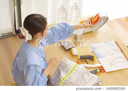 檢查防災用品的女性 檢查防災用品的女性 140990389