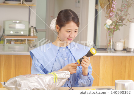 檢查防災用品的女性 檢查防災用品的女性 140990392