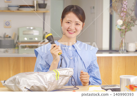 A woman checking disaster prevention goods A woman checking disaster prevention goods 140990393