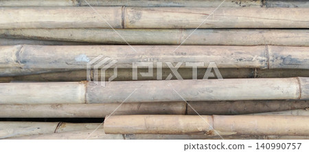 A stack of dried bamboo poles with a natural texture and neutral colors. A stack of dried bamboo poles with a natural texture and neutral colors. 140990757