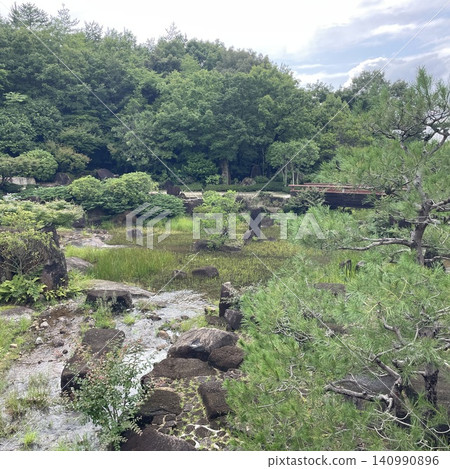 日式庭園景觀,四周環繞著靜謐的水景和綠植。 日式庭園景觀,四周環繞著靜謐的水景和綠植。 140990896